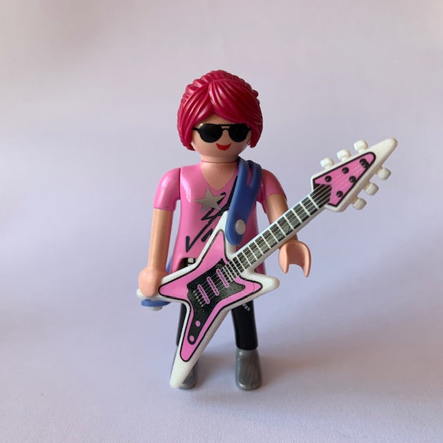 Mujer con guitarra, gafas y pelo rosa